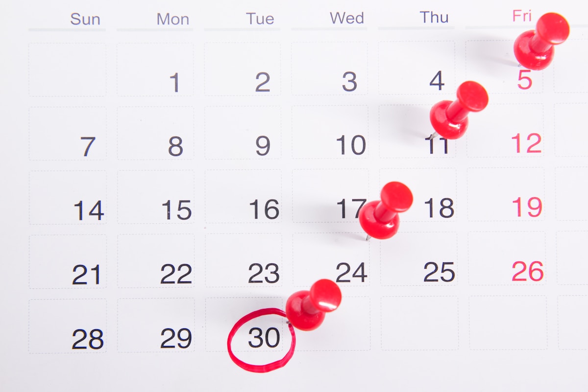 Calendar with red pins marking a countdown of days toward an exam date