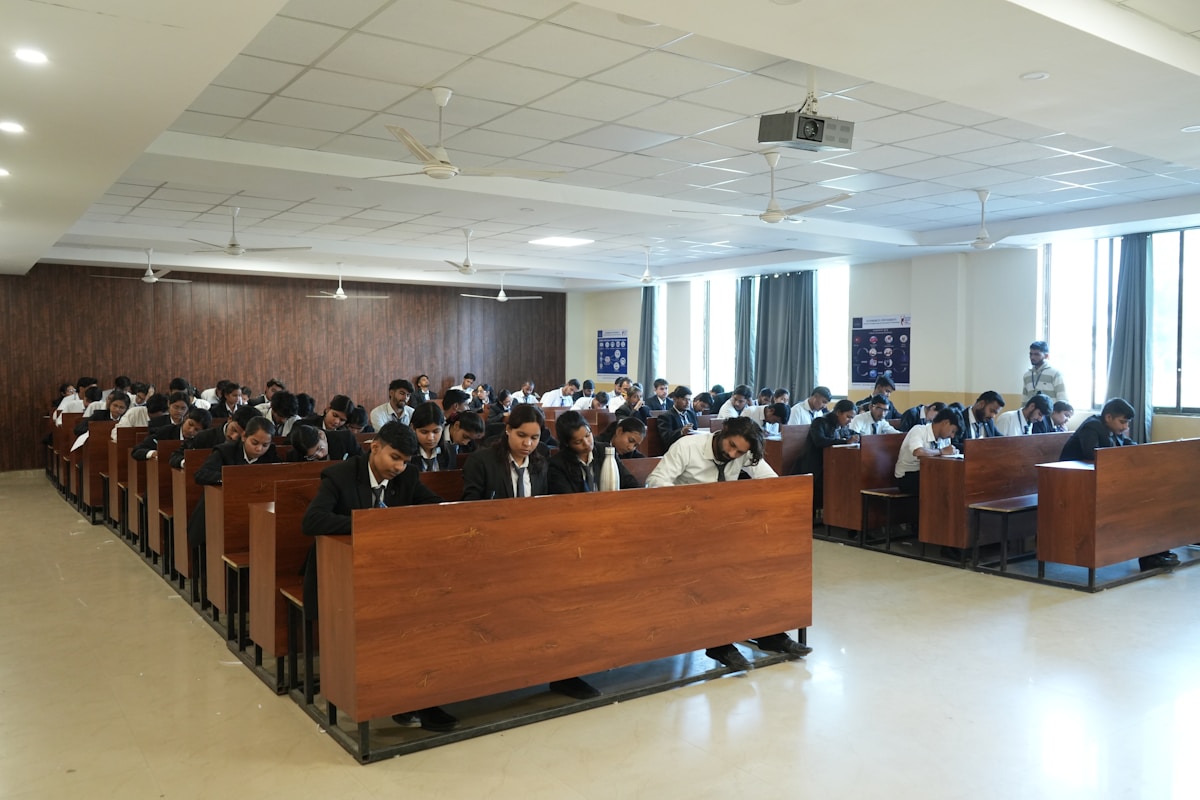 Rows of students taking a written exam in a large classroom