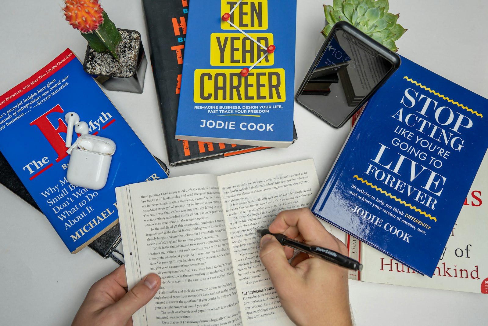 Person writing in a notebook surrounded by professional development books