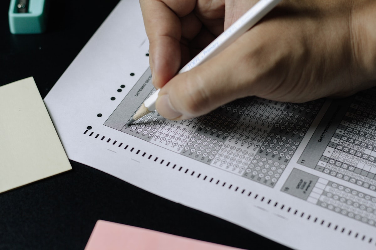Person writing notes at a desk preparing for an exam