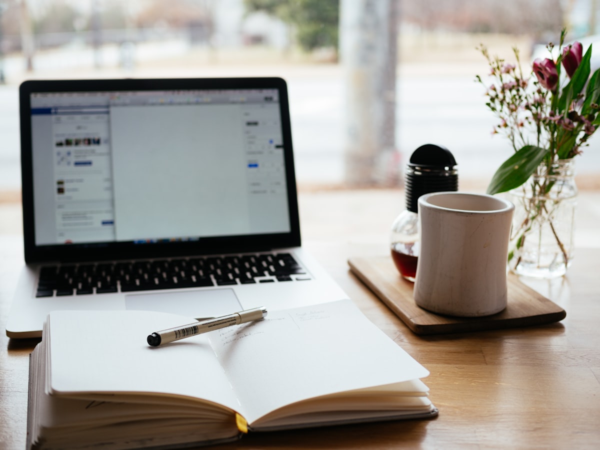 Open laptop with notes and books on a desk ready for studying