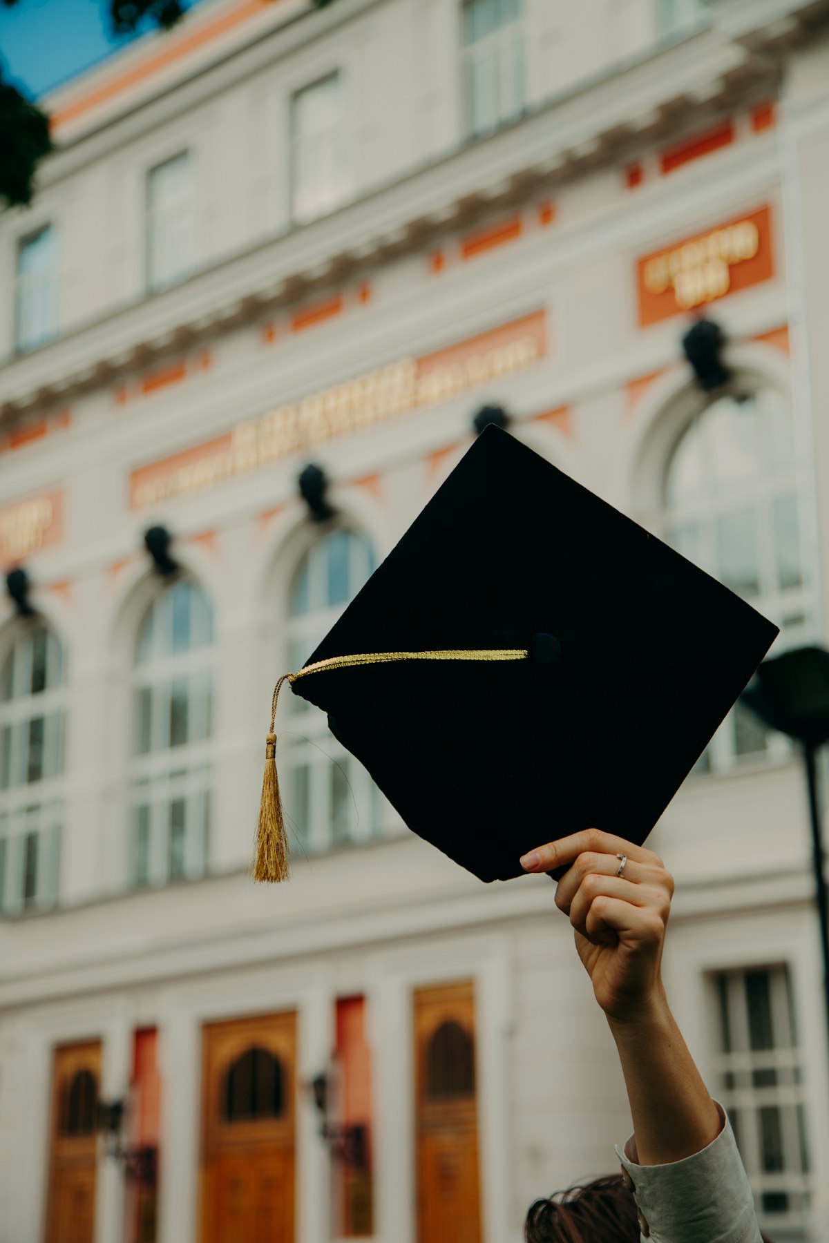 Person holding a graduation cap, representing academic achievement and graduate study