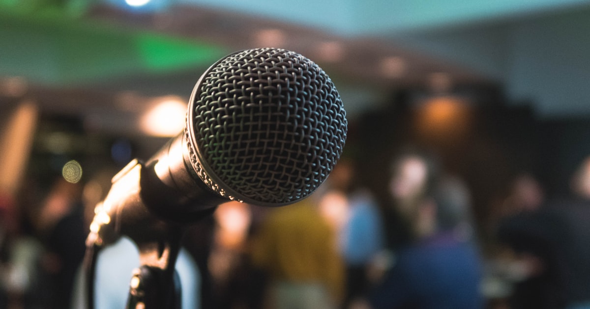 Person practicing a speech in front of a microphone with confidence