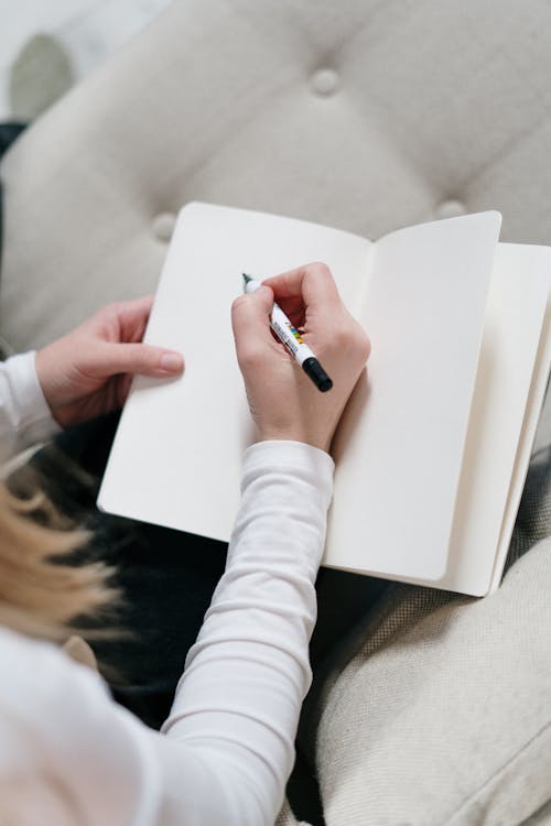 Person writing in a notebook at a desk