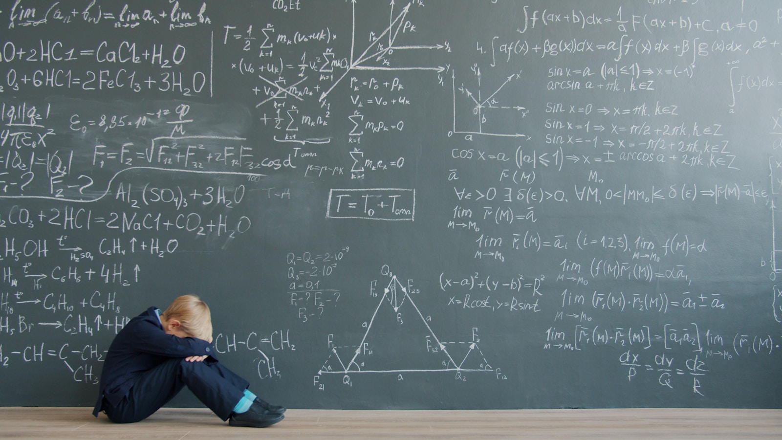 Student sitting in front of a blackboard covered in math equations