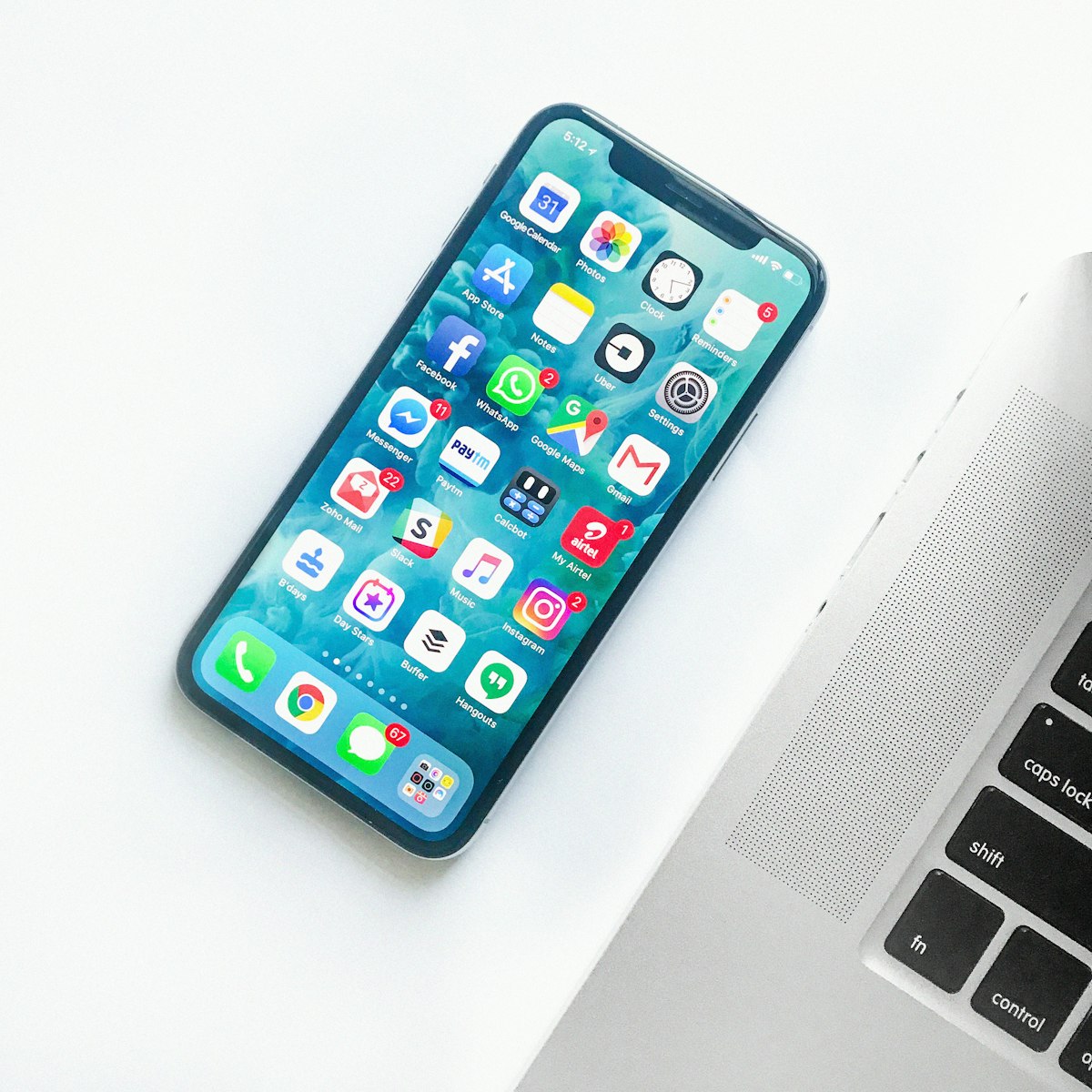 iPhone with a study app on screen next to a laptop
