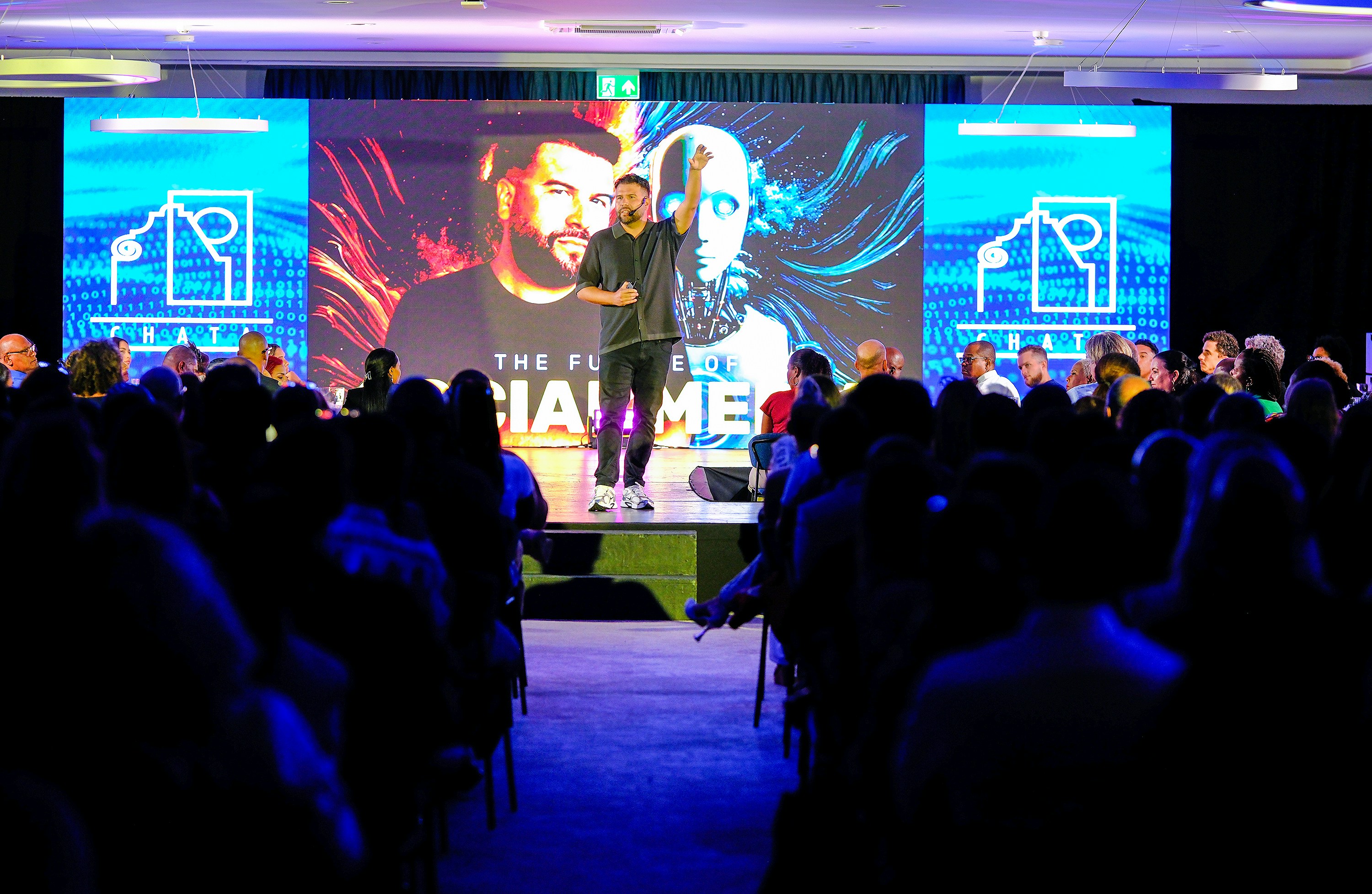 Speaker presenting on stage to an audience without notes