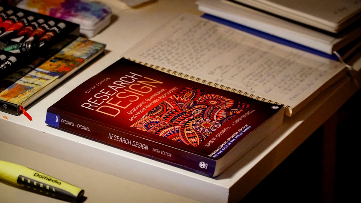 Research books and academic notes on a desk for thesis preparation
