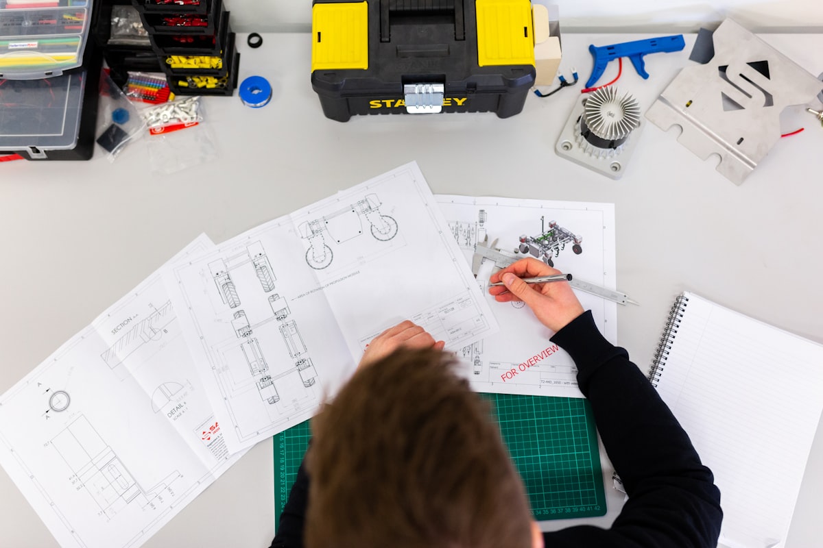 Engineer working at a desk with technical drawings and blueprints