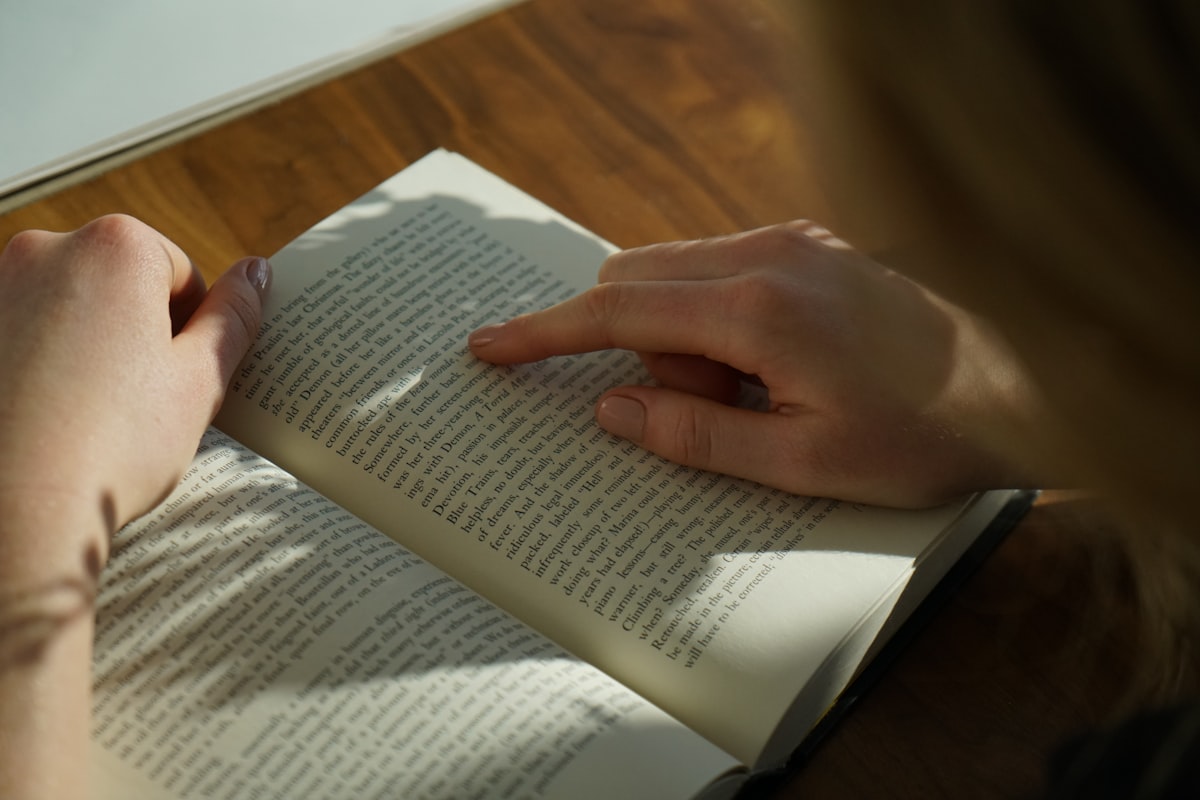 Person carefully reading and focusing on a book or exam paper