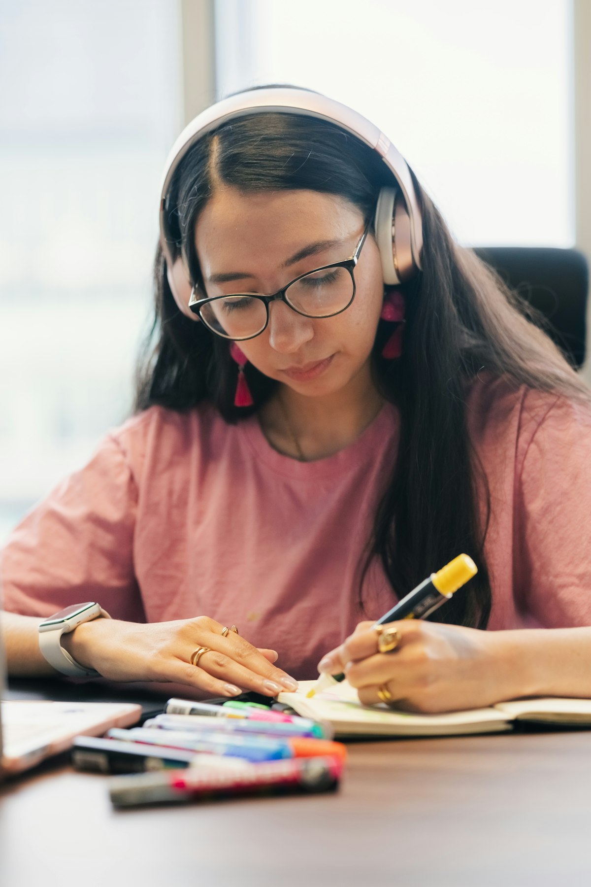 Student focused at a desk with headphones, studying intently