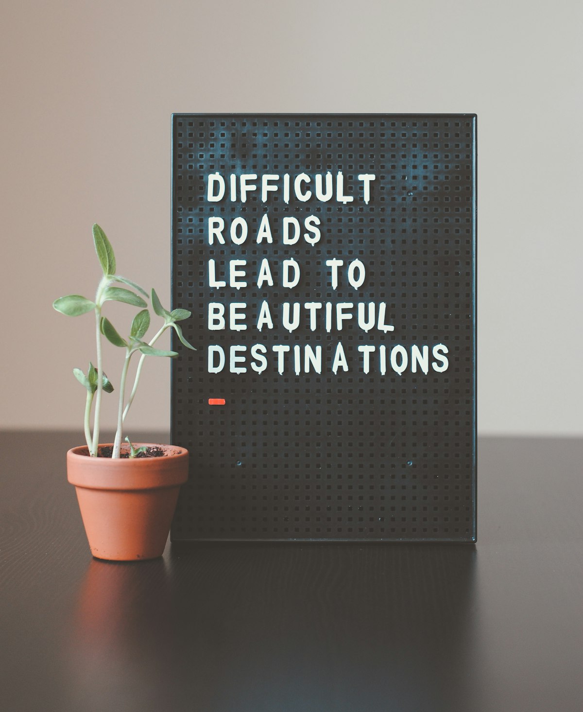 Motivational desk with a sign saying difficult roads lead to beautiful destinations