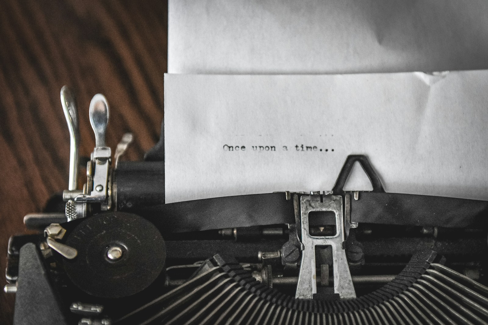 Vintage typewriter with 'once upon a time' typed on paper, representing narrative and storytelling