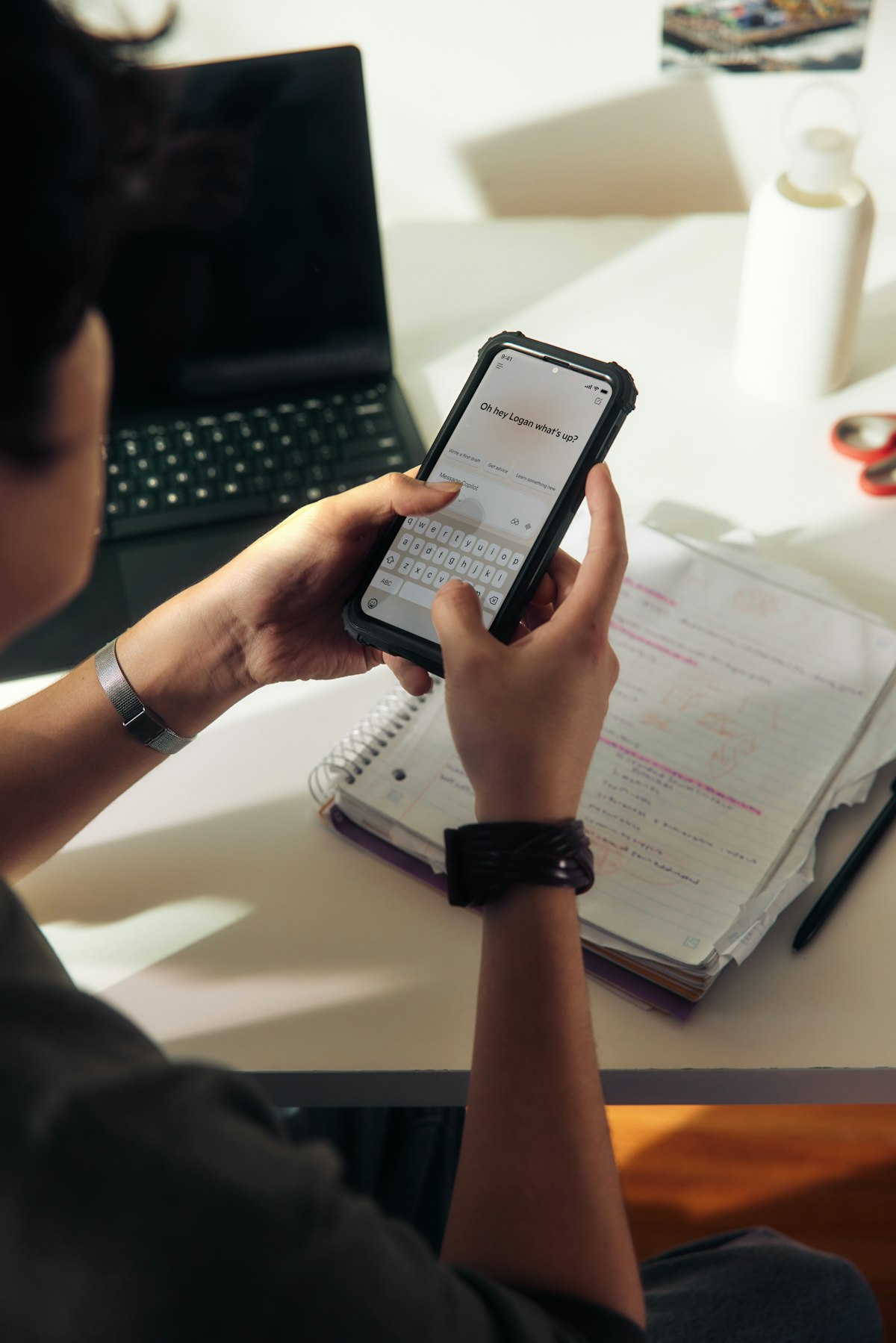 Student studying with a notebook and smartphone, focused on difficult material