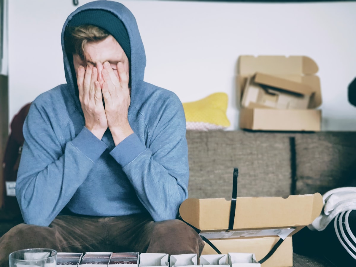 Exhausted student with head on desk surrounded by books