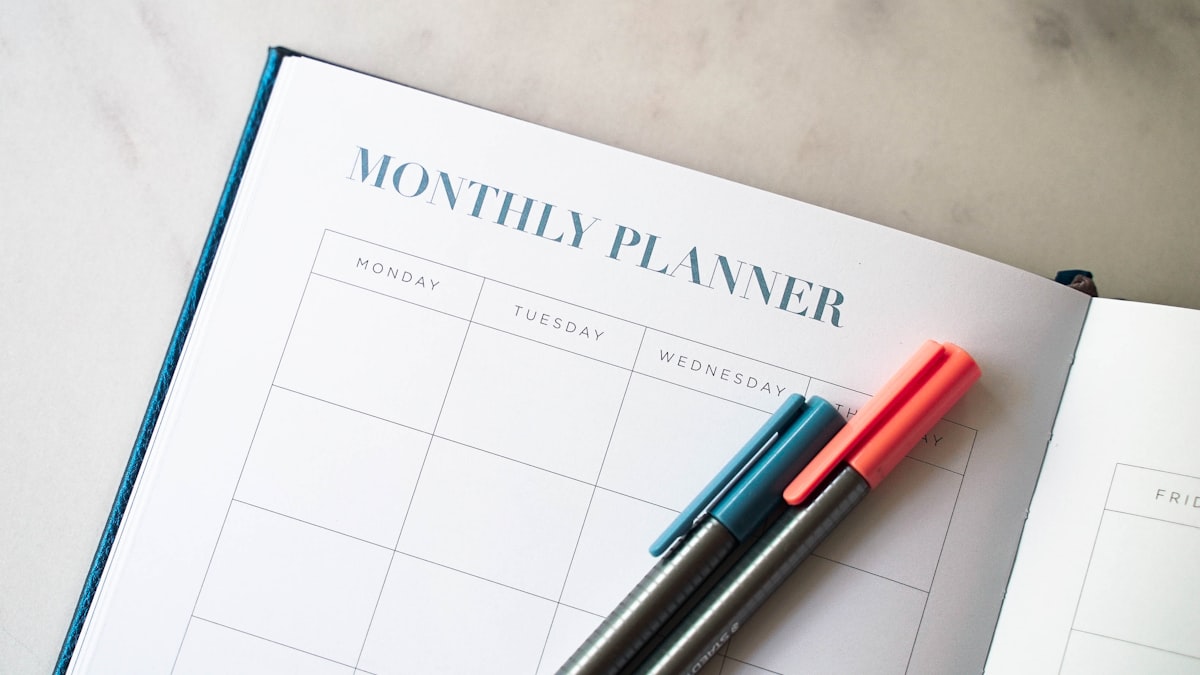 Weekly planner with pens on a desk representing study planning templates