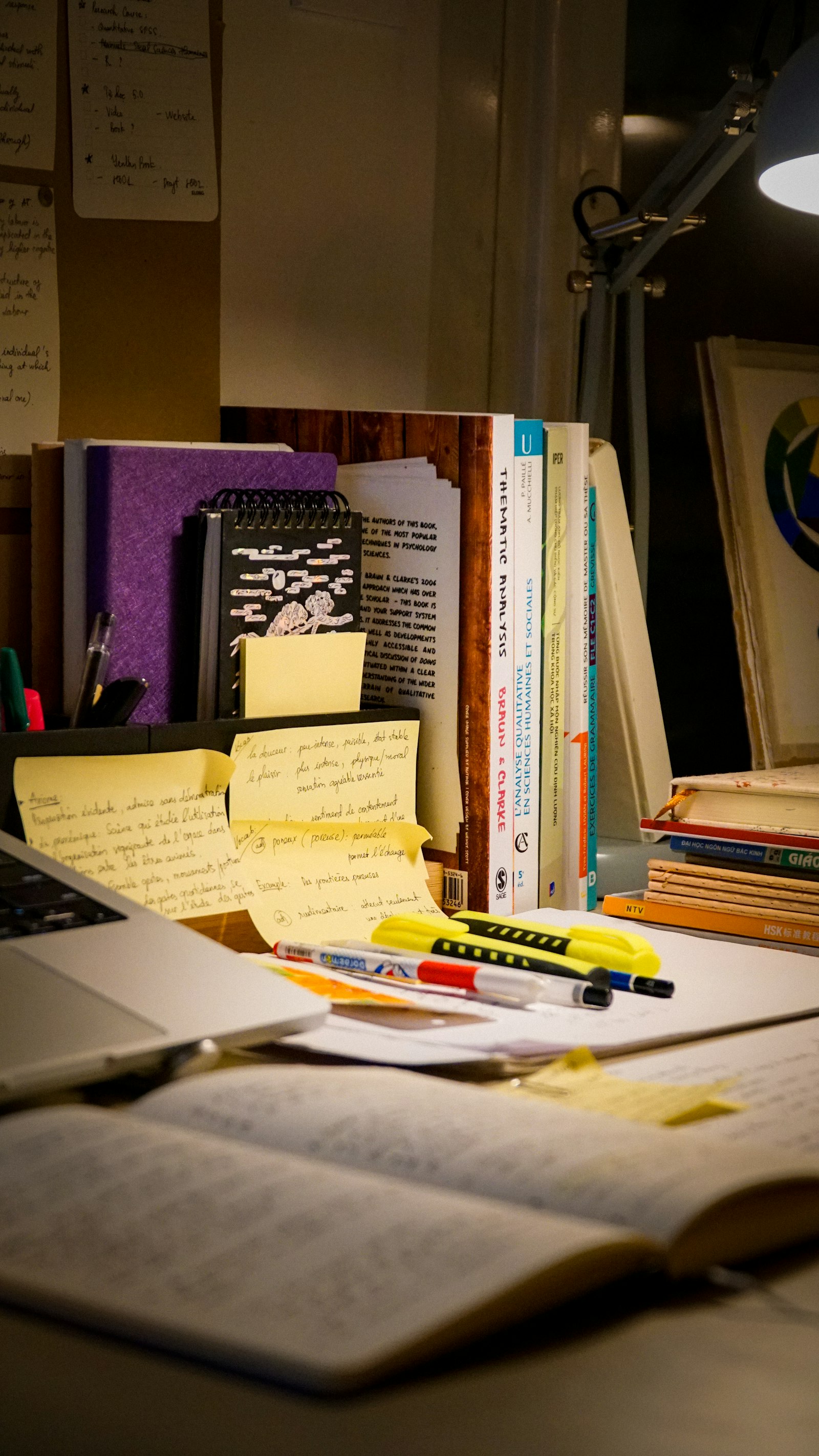 Desk with open book, laptop, and notebook representing a personal study system