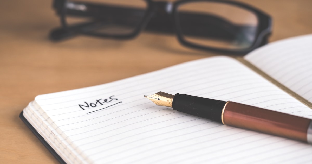 Person writing in a notebook with focused expression to memorize information quickly