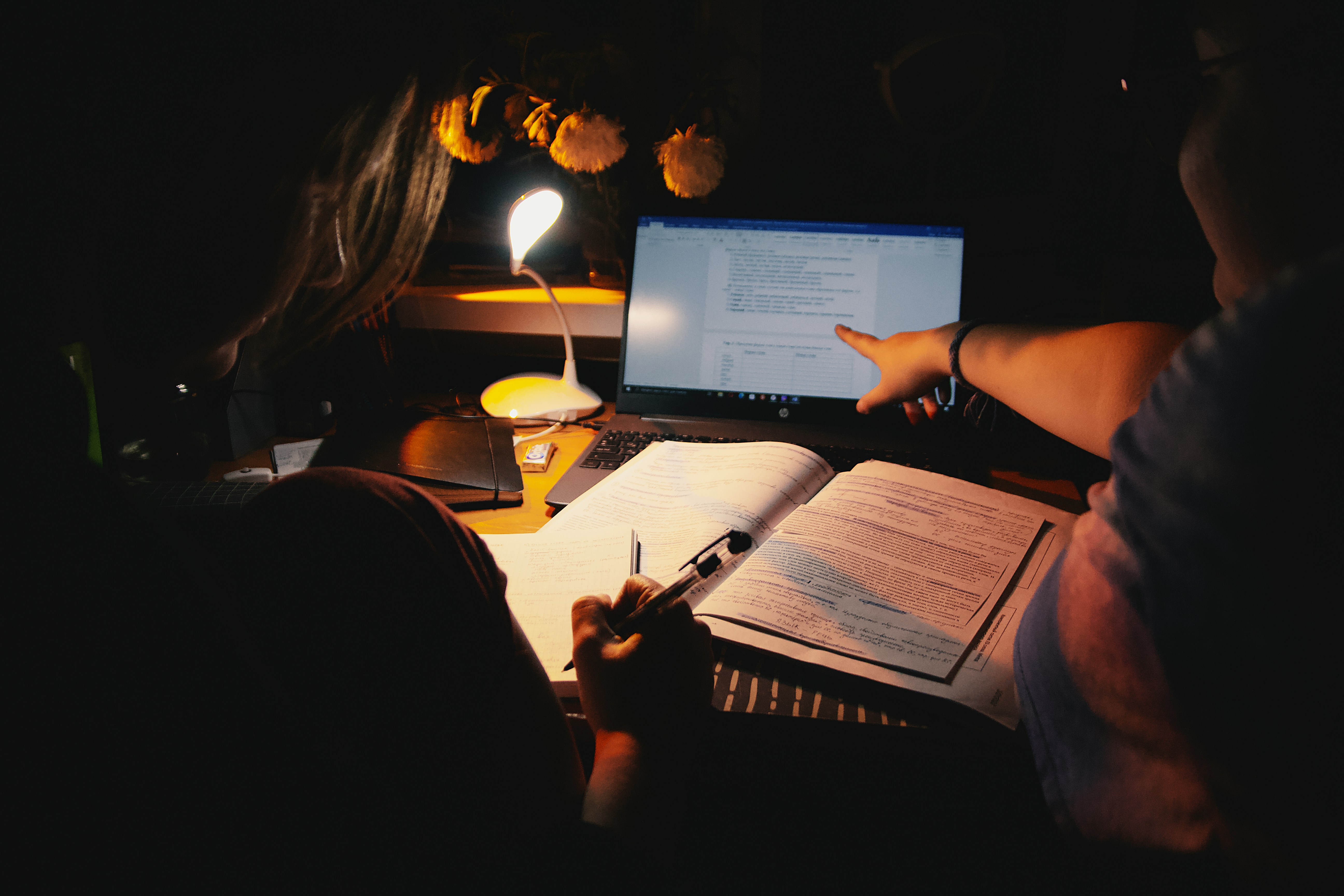 Student actively studying with notes and laptop at a desk